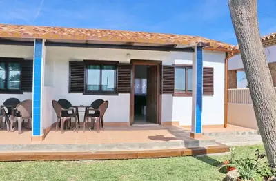 a house with a patio with a table and chairs at Bungalow Ramos II in Conil de la Frontera