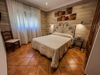 a bedroom with a bed in a room with wooden walls at Villa Rosal- Solo familias y parejas in Conil de la Frontera