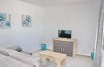 a living room with a couch and a tv on a table at Chalet Lobita in Conil de la Frontera