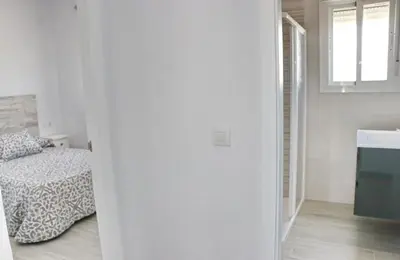 a white room with a bed and a sink at Chalet Lobita in Conil de la Frontera