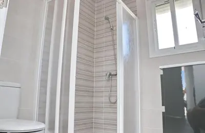 a bathroom with a shower with a toilet and a window at Chalet Lobita in Conil de la Frontera