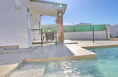 a house with a swimming pool and a patio with a table at Chalet Lobita in Conil de la Frontera