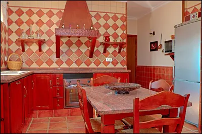 a kitchen with a table with chairs and a refrigerator at Chalet Puente de Tabla in Conil de la Frontera