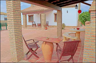 a patio with a table and two chairs and a table at Chalet Puente de Tabla in Conil de la Frontera