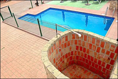 a swimming pool with a brick wall around it at Chalet Puente de Tabla in Conil de la Frontera