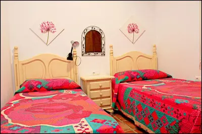 a bedroom with two beds and a mirror at Chalet Puente de Tabla in Conil de la Frontera