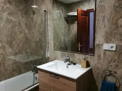 a bathroom with a sink and a mirror and a tub at Apartamento Aldama en el centro de Sanlúcar de Barrameda in Sanlúcar de Barrameda