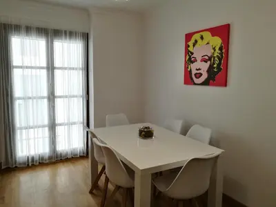 a dining room with a white table and chairs at Apartamento Aldama en el centro de Sanlúcar de Barrameda in Sanlúcar de Barrameda