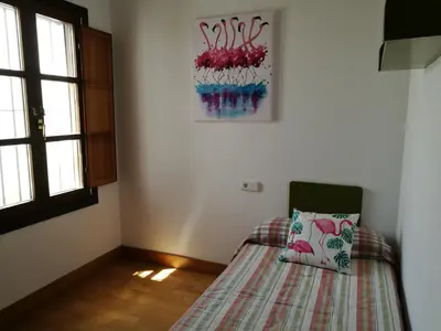 a bedroom with a bed with a pillow on it at Apartamento Aldama en el centro de Sanlúcar de Barrameda in Sanlúcar de Barrameda
