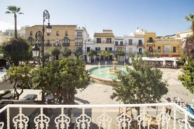 a view from a balcony of a town with a fountain at Apartamento ateneo in Sanlúcar de Barrameda