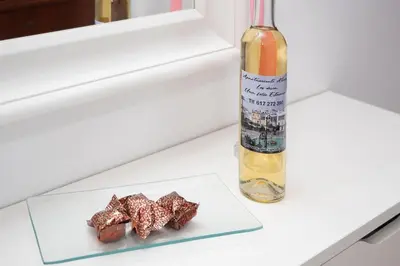 a bottle of wine and two pieces of food on a table at Apartamento ateneo in Sanlúcar de Barrameda
