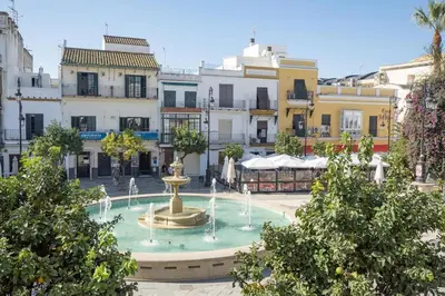 a fountain in the middle of a city with buildings at Apartamento ateneo in Sanlúcar de Barrameda