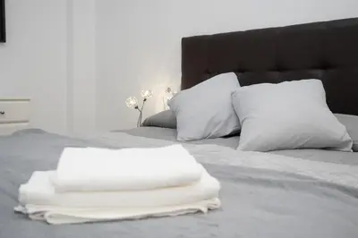 a bed with white sheets and pillows on it at Apartamento ateneo in Sanlúcar de Barrameda