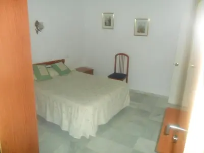 a bedroom with a bed and a chair at Hostal Centro Sol in Cádiz