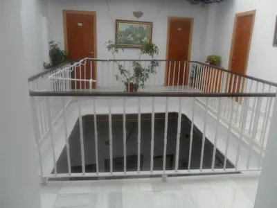 a white staircase with a railing in a room at Hostal Centro Sol in Cádiz