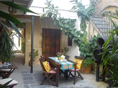 a table and chairs in a courtyard with plants at Apartamentos El Patio Andaluz in Jerez de la Frontera