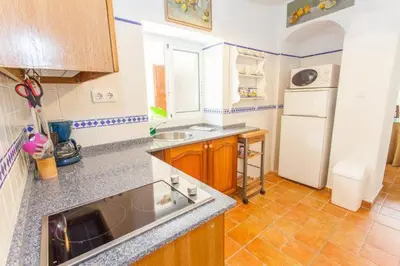 a kitchen with a sink and a white refrigerator at Apartamentos El Patio Andaluz in Jerez de la Frontera
