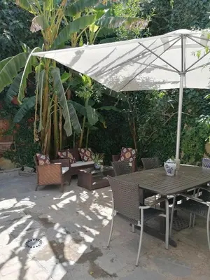 a table and chairs under a white umbrella at Apartamentos El Patio Andaluz in Jerez de la Frontera