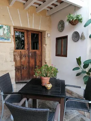 a patio table with chairs and a wooden door at Apartamentos El Patio Andaluz in Jerez de la Frontera
