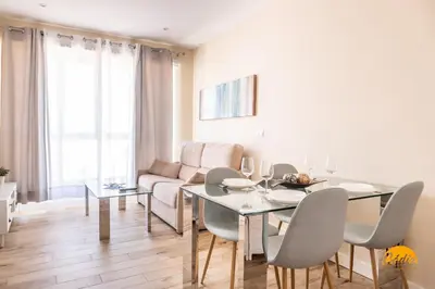 a dining room with a table and chairs and a couch at Apartamentos Ancha 22 by Cadiz Time in Cádiz