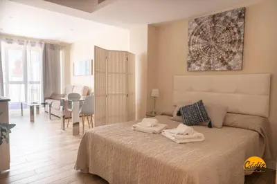 a bedroom with a bed with two towels on it at Apartamentos Ancha 22 by Cadiz Time in Cádiz