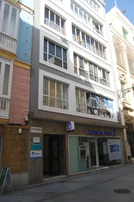 a large white building on the corner of a street at Apartamentos Ancha 22 by Cadiz Time in Cádiz