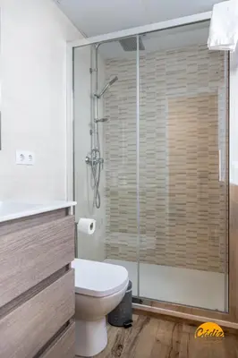 a bathroom with a toilet and a glass shower at Apartamentos Ancha 22 by Cadiz Time in Cádiz
