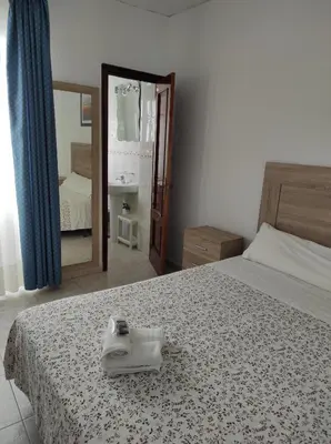 a bedroom with a bed with a mirror and a sink at Hostal Fantoni in Cádiz