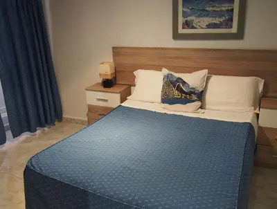 a bedroom with a bed with a blue comforter at Hostal Fantoni in Cádiz