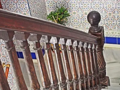 a wooden stair railing in a room with a wall at Hostal Fantoni in Cádiz