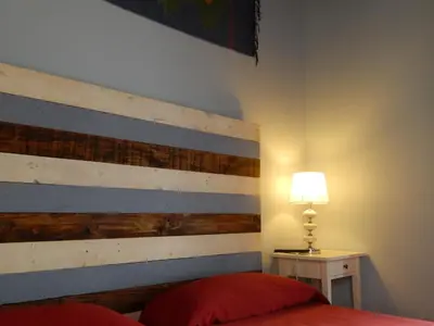 a bedroom with a bed with a wooden headboard and a lamp at Hospederia Marqués in Cádiz