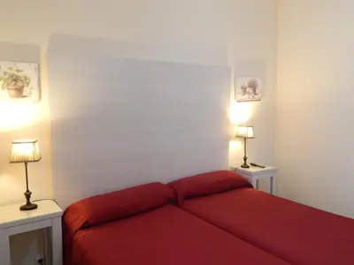 a bedroom with a red bed and two lamps at Hospederia Marqués in Cádiz