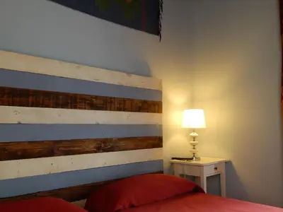 a bedroom with a bed with a wooden headboard at Hospederia Marqués in Cádiz