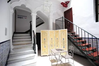 a room with stairs and a table and a stair case at Hospederia Marqués in Cádiz