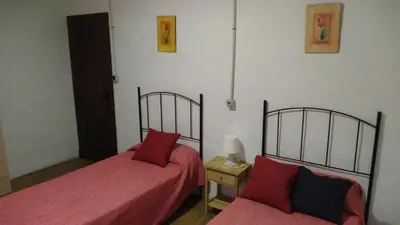 two beds in a room with red sheets at Alojamiento Rural - Finca Santa Margarita in Algar