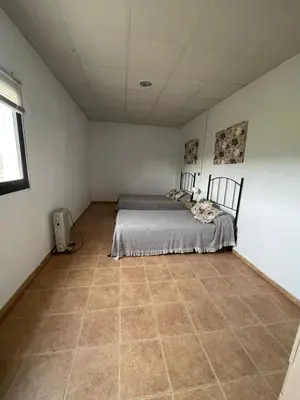 a bedroom with two beds and a tiled floor at Alojamiento Rural - Finca Santa Margarita in Algar