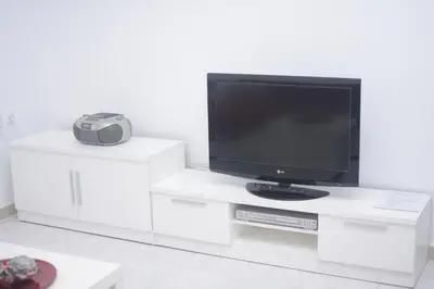 a white entertainment center with a television on top at San Francisco's House in Medina Sidonia