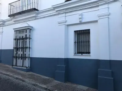 a blue and white building with barred windows at San Francisco's House in Medina Sidonia