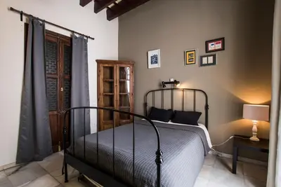 a bedroom with a bed and a lamp on a table at Casa Caracol in Cádiz