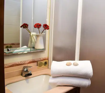 a bathroom with a sink and a mirror and towels at Apartamento Barrosaplaya1 in Chiclana de la Frontera