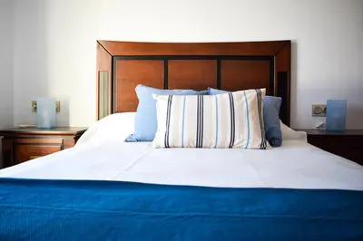 a bedroom with a large bed with a wooden headboard at Apartamento Barrosaplaya1 in Chiclana de la Frontera