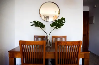 a dining room table with two chairs and a mirror at Apartamento Barrosaplaya1 in Chiclana de la Frontera