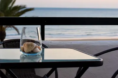 a glass vase sitting on a table near the beach at Apartamento Barrosaplaya1 in Chiclana de la Frontera