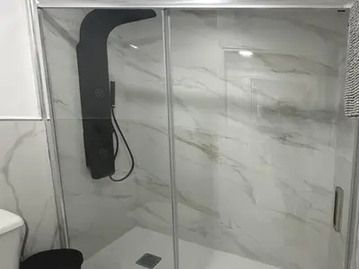 a shower with a glass door in a bathroom at Gran Teatro Falla in Cádiz