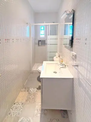 a white bathroom with a sink and a toilet at Gran Teatro Falla in Cádiz