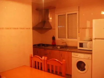 a kitchen with a white refrigerator and a washing machine at Apartamentos Las Parcelas in Conil de la Frontera