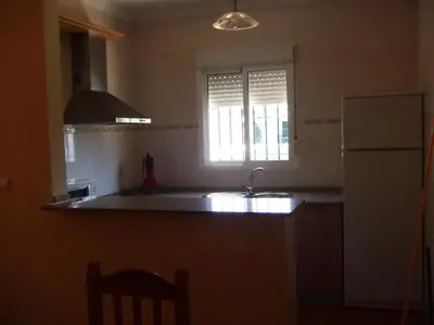 a kitchen with a sink and a refrigerator and a window at Apartamentos Las Parcelas in Conil de la Frontera