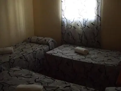two beds in a small room with a window at Apartamentos Las Parcelas in Conil de la Frontera