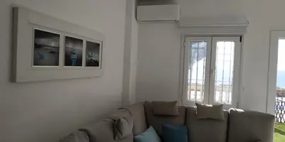 a living room with a couch and two windows at Kiana Mirador Puerto Sherry con parking in El Puerto de Santa María