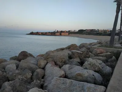 a pile of rocks next to a body of water at Kiana Mirador Puerto Sherry con parking in El Puerto de Santa María